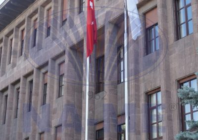 Taş bina cephesi önündeki çift paslanmaz çelik bayrak direği