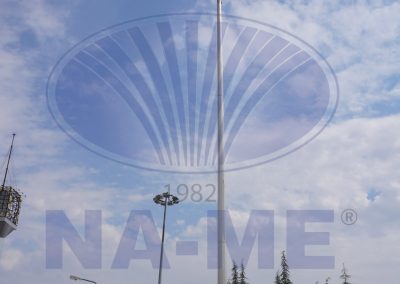 Bulutlu gökyüzüne uzanan çift paslanmaz çelik bayrak direği