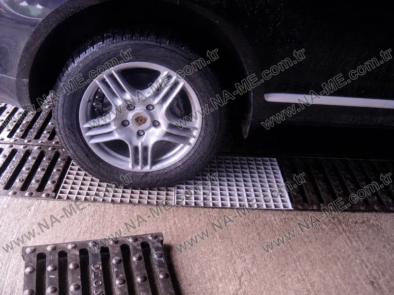 Araç yıkama alanında otomobil tekeri altında açık renk polyester kanal ızgarası