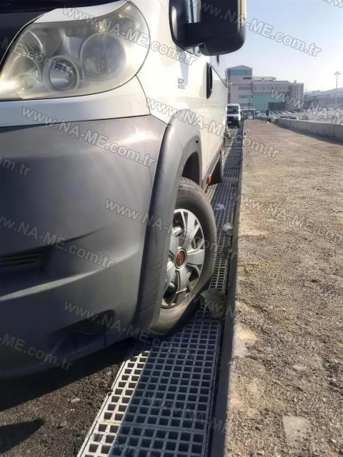Traffic-rated trench grating along a roadside