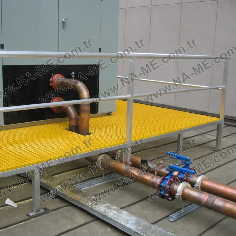 Yellow grating platform with a rail over pipelines