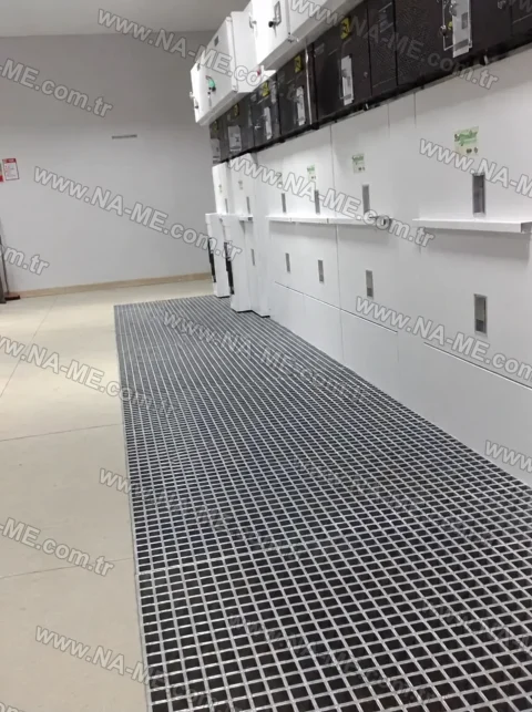 Grating walkway by a panel in an electrical room