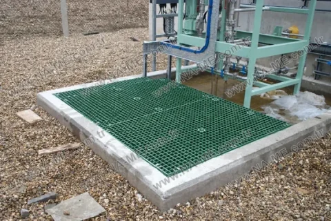 Green grating over a concrete pit on a gravel roof