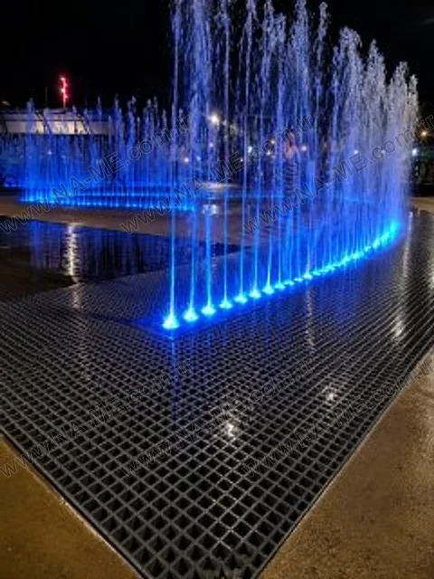 Grating floor under lit water jets at night