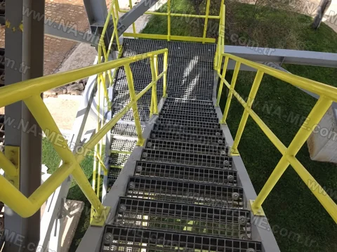Grey grating stair treads with a yellow handrail