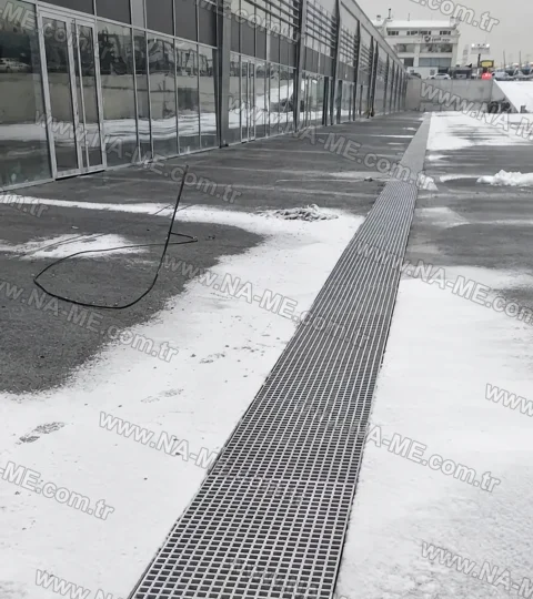 Trench grating around a mall in snowy weather