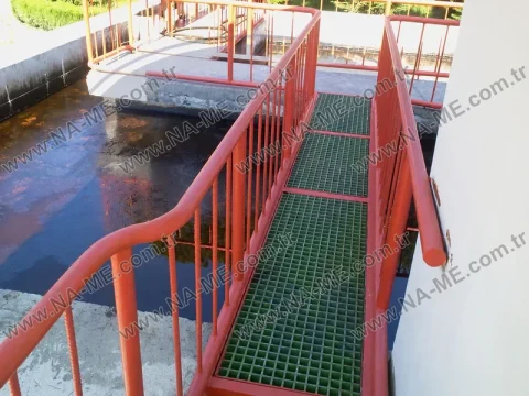 Green grating walkway with a rail over a treatment pool