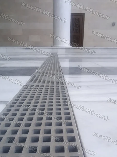 Long-run trench grating in a marble courtyard