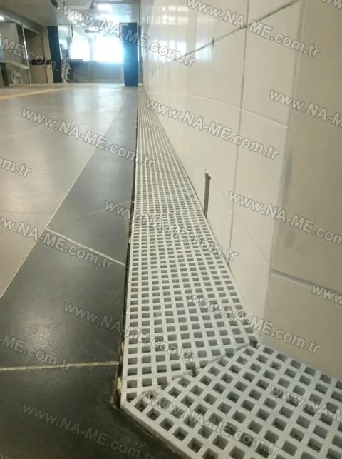 Slim drainage line along a wall in a metro passage