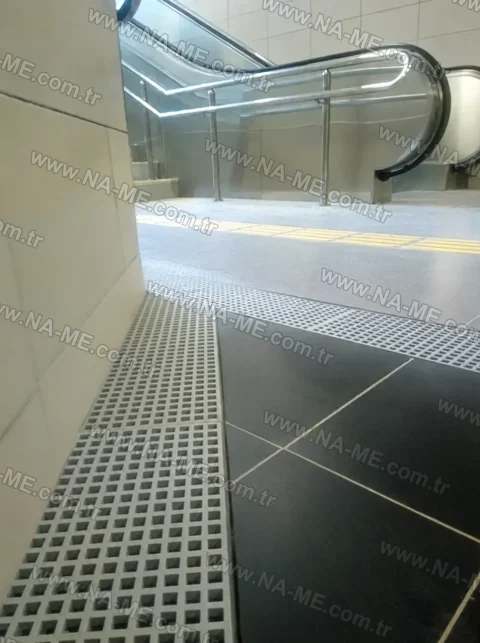 Trench grating in front of an escalator at a metro station