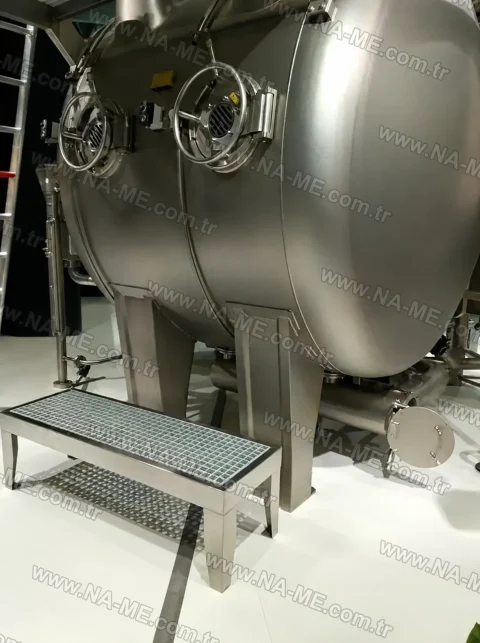 Grating access step in front of a stainless tank