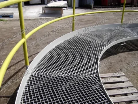 Curved grating walkway with a yellow handrail