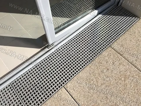 Rainwater grating at a terrace door threshold